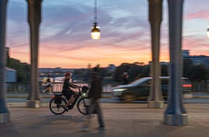 Cycliste sur le pont Bir-Hakeim à Paris avec coucher de soleil
